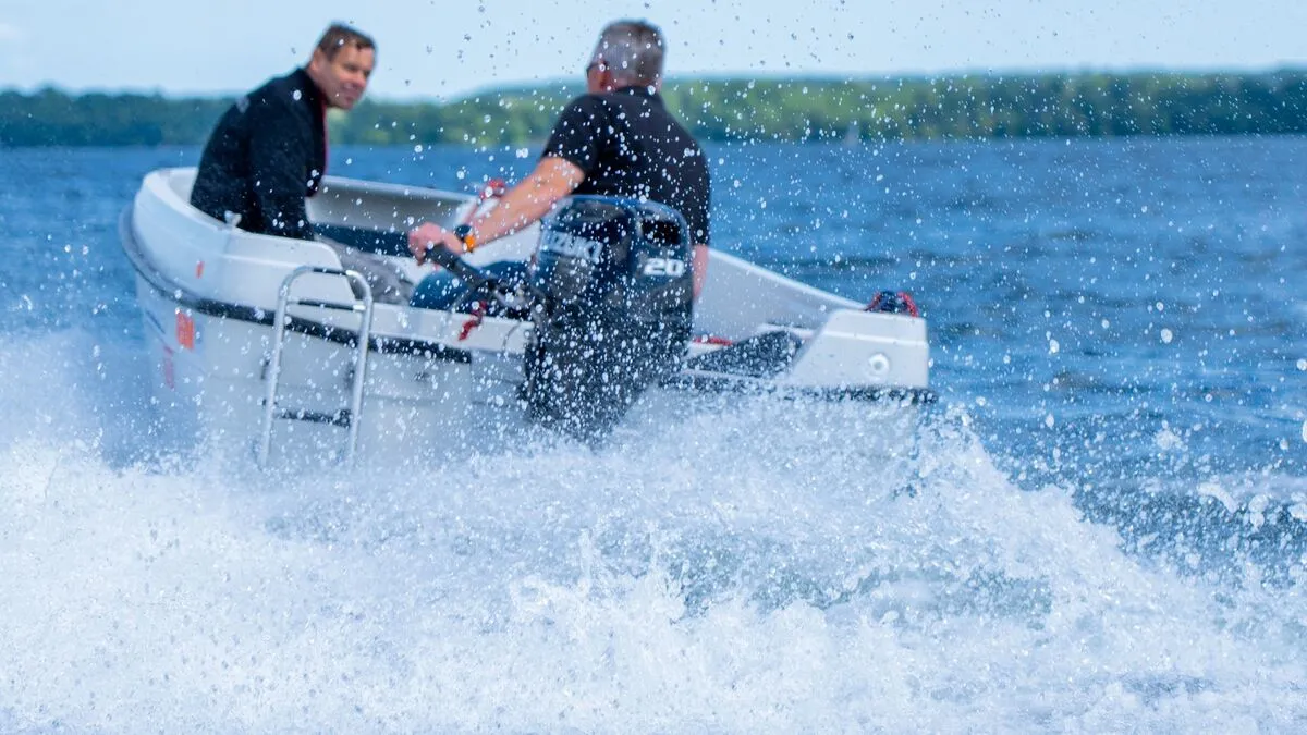 Person water testing an outboard motor on a boat