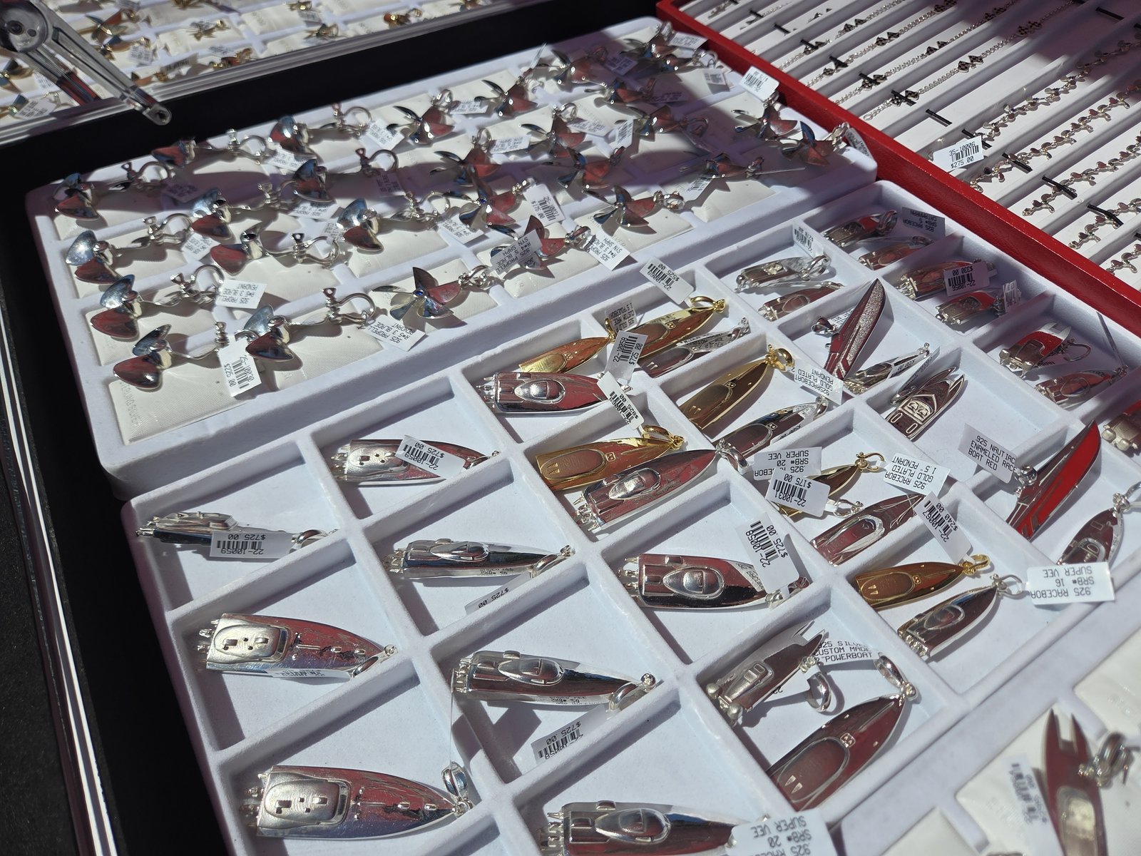 Tray of race-boat shaped pendants