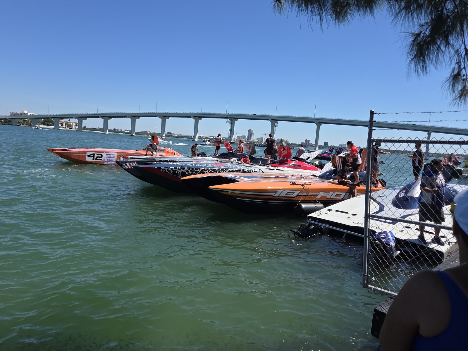 Row of offshore race boats along the seawall by the bridge