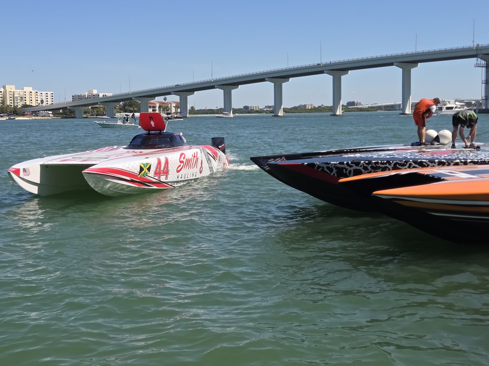 Race boat number 44 in the water near the bridge
