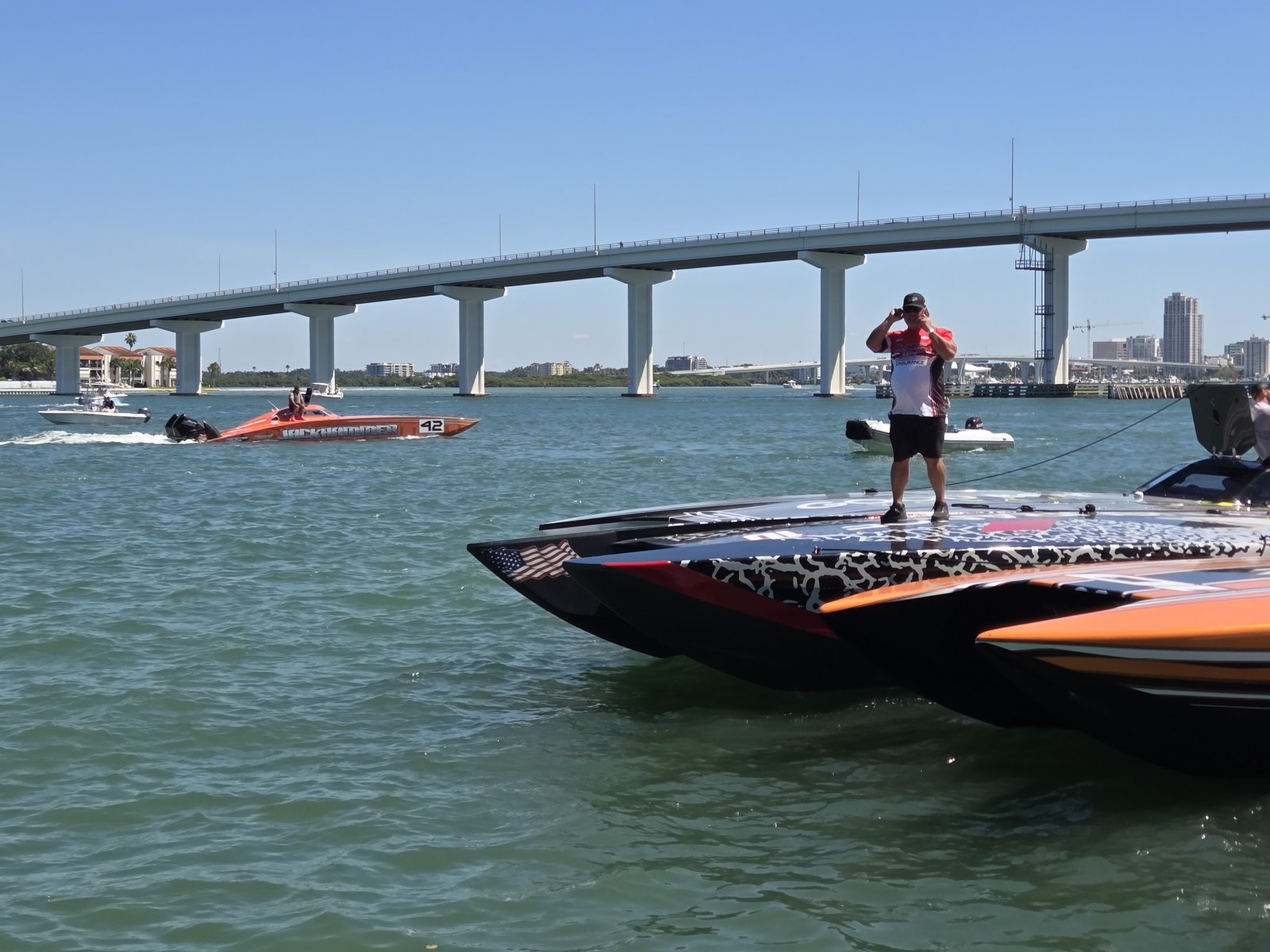 Crew member standing on the deck of a race boat by the bridge