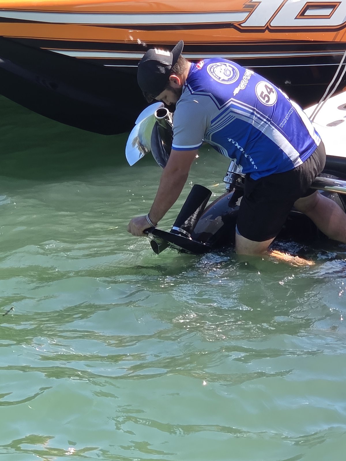 Crew member in the water working on an outboard lower unit on boat number 10