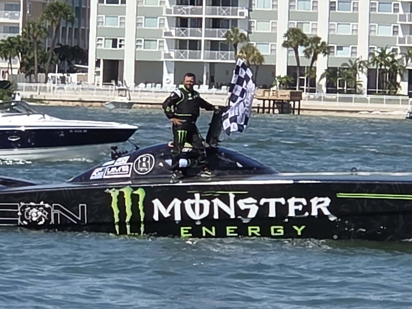 Monster Energy race boat driver holding the checkered flag at Clearwater