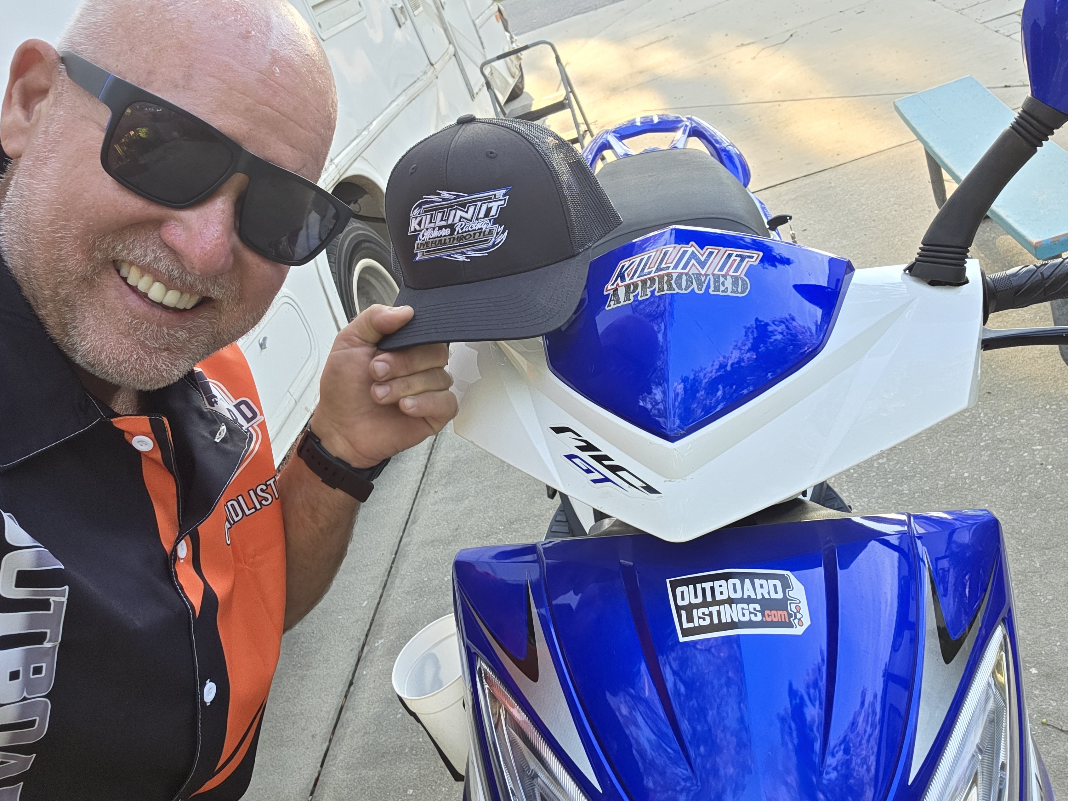 Selfie with a KillinIt Approved hat on a blue and white scooter with an OutboardListings.com sticker