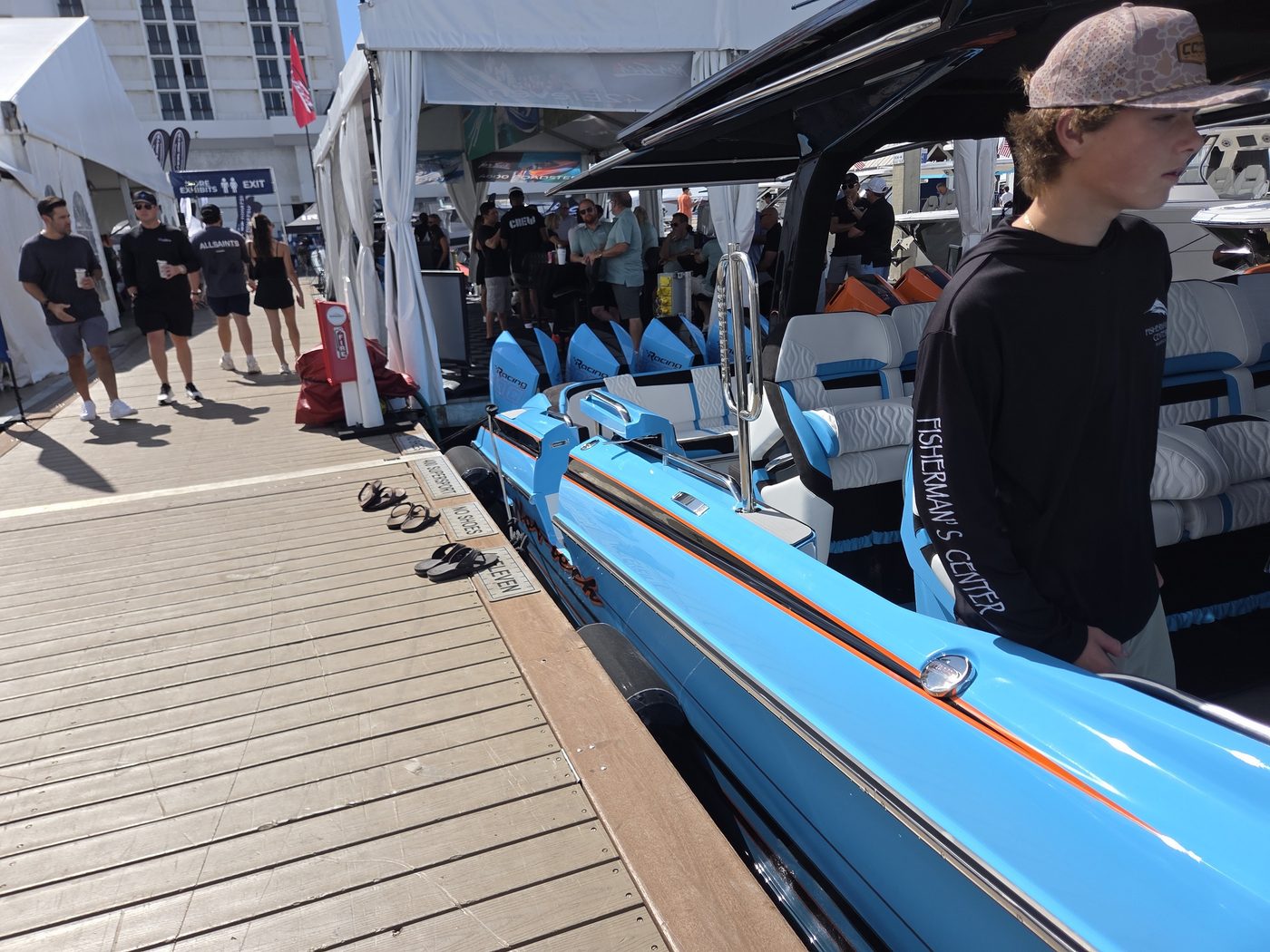 Baby blue sport boat at the dock with show visitors