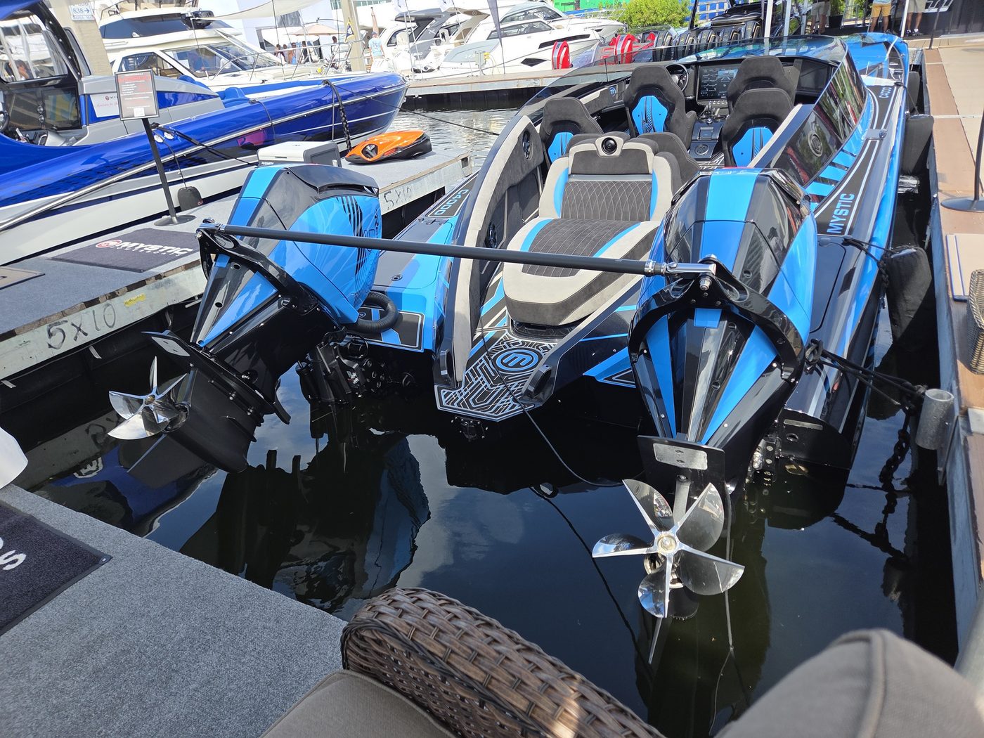 Blue and black performance catamaran with twin outboards tilted up