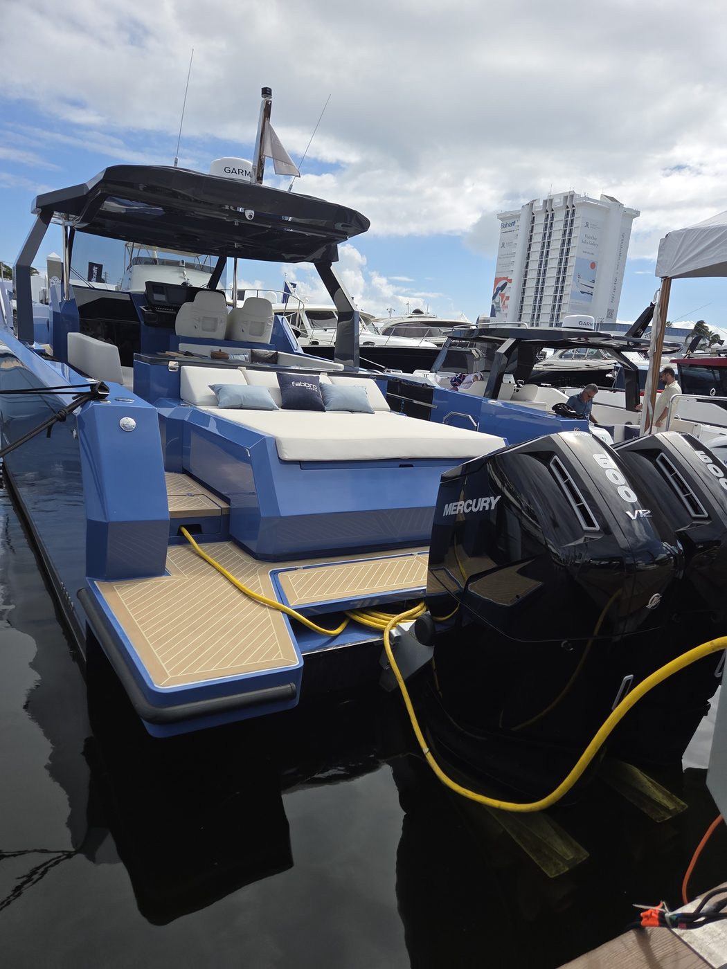 Blue dayboat with twin black outboards and teak deck