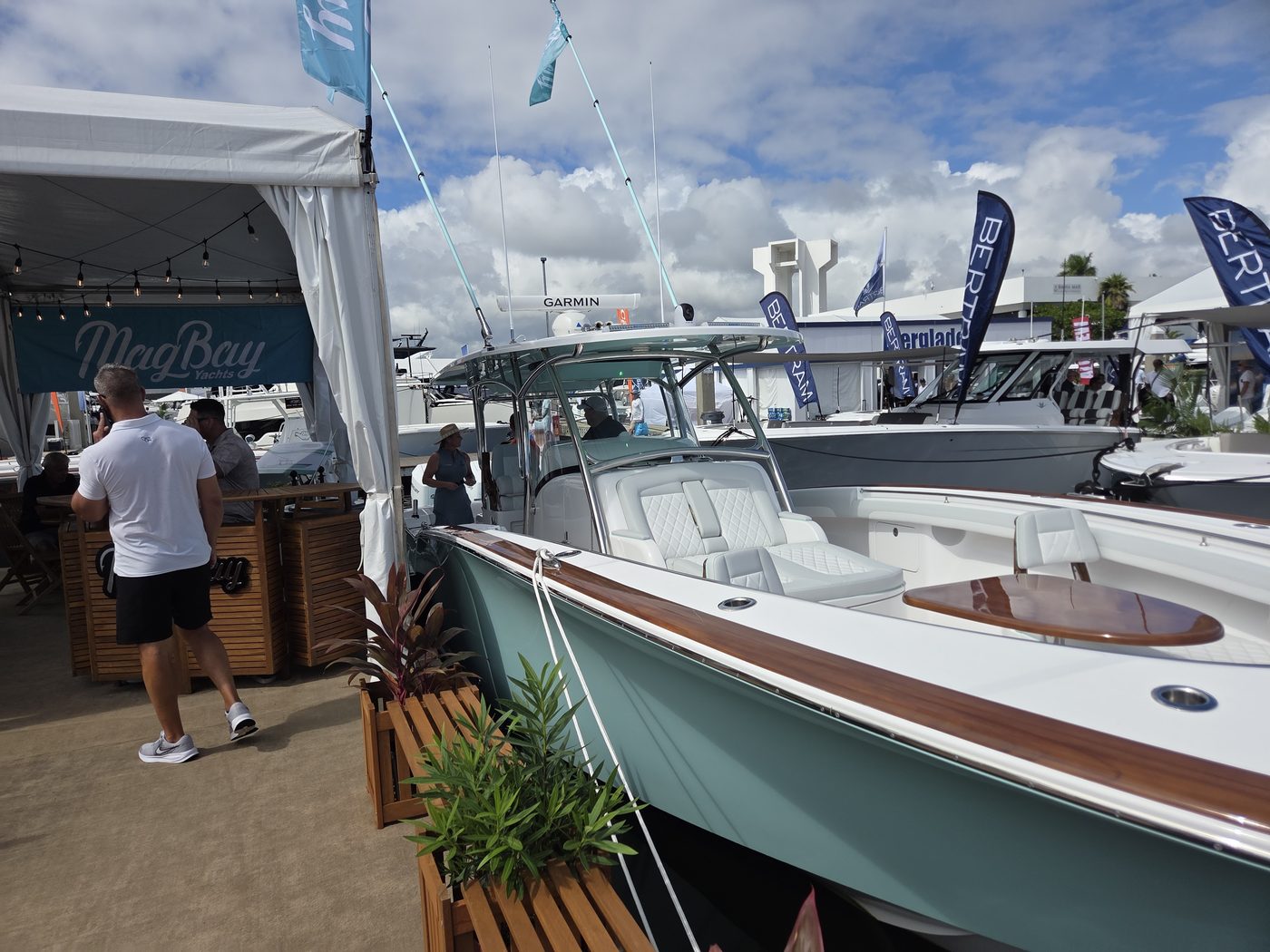 Teal center console beside a dockside lounge tent