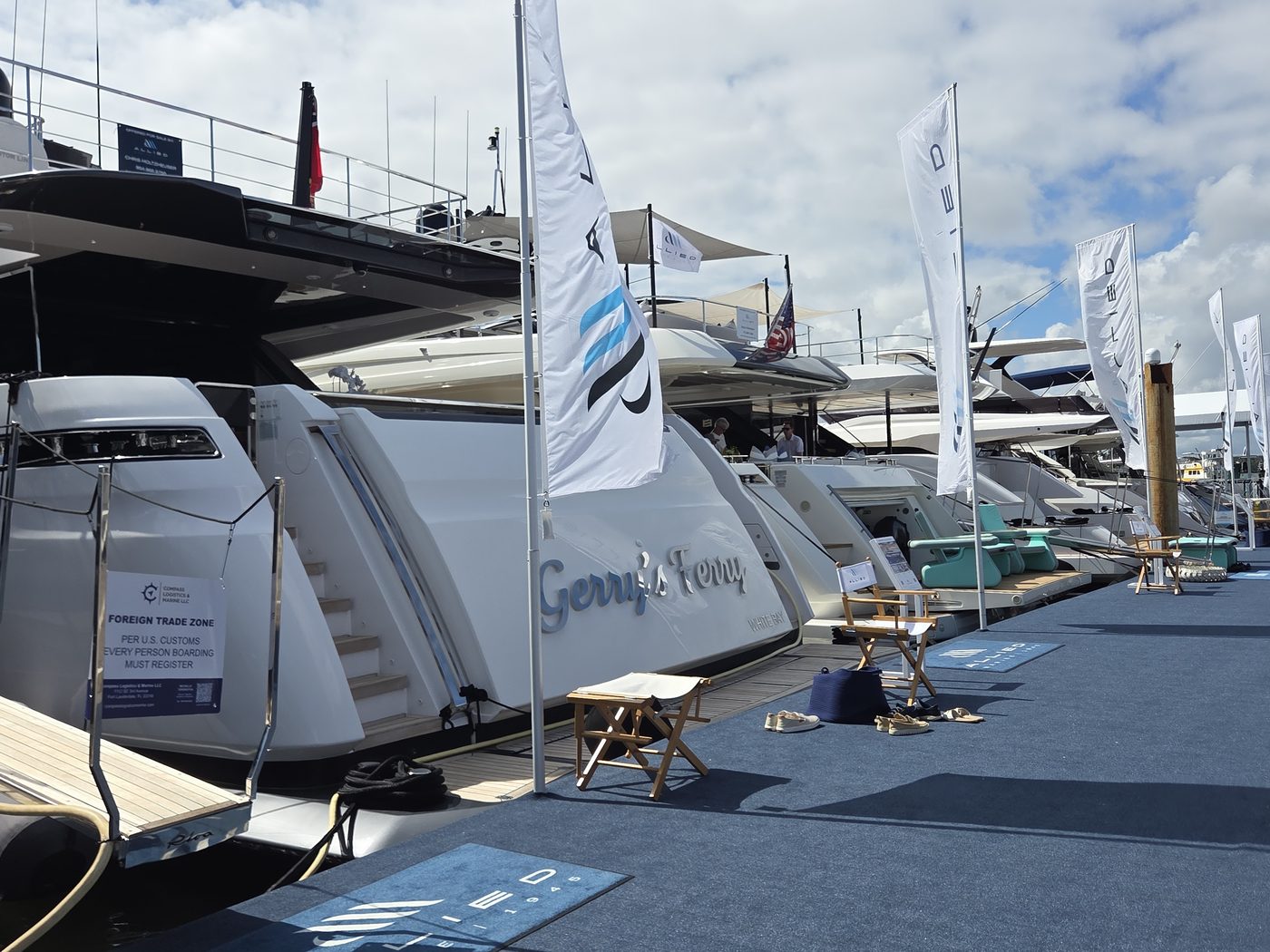 Motor yachts along a carpeted dock at FLIBS 2026