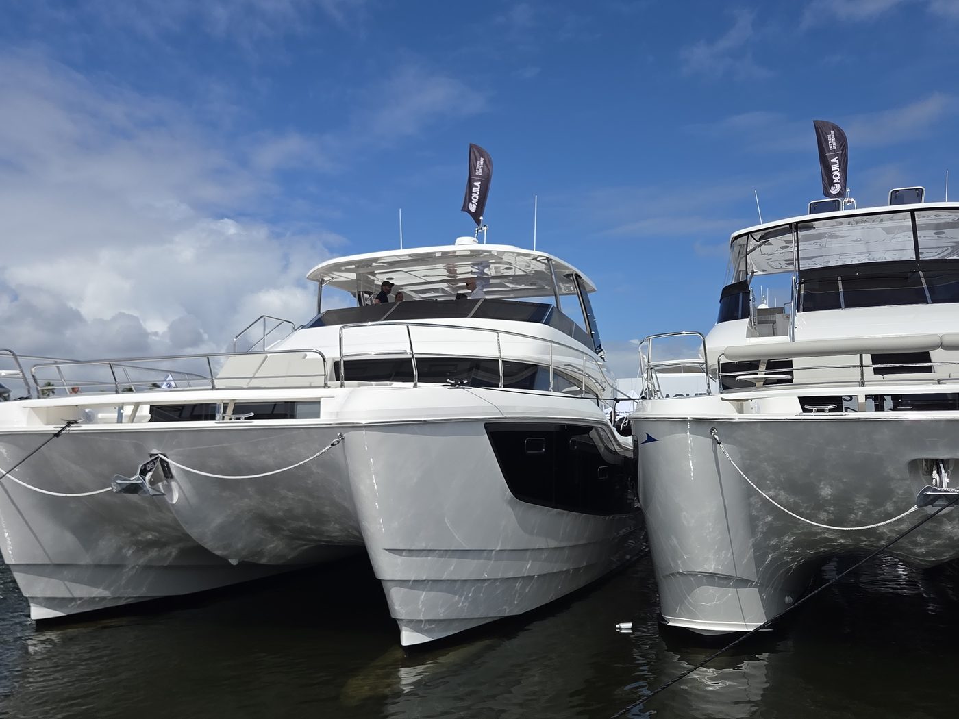 Two white power catamarans bow-in at FLIBS 2026