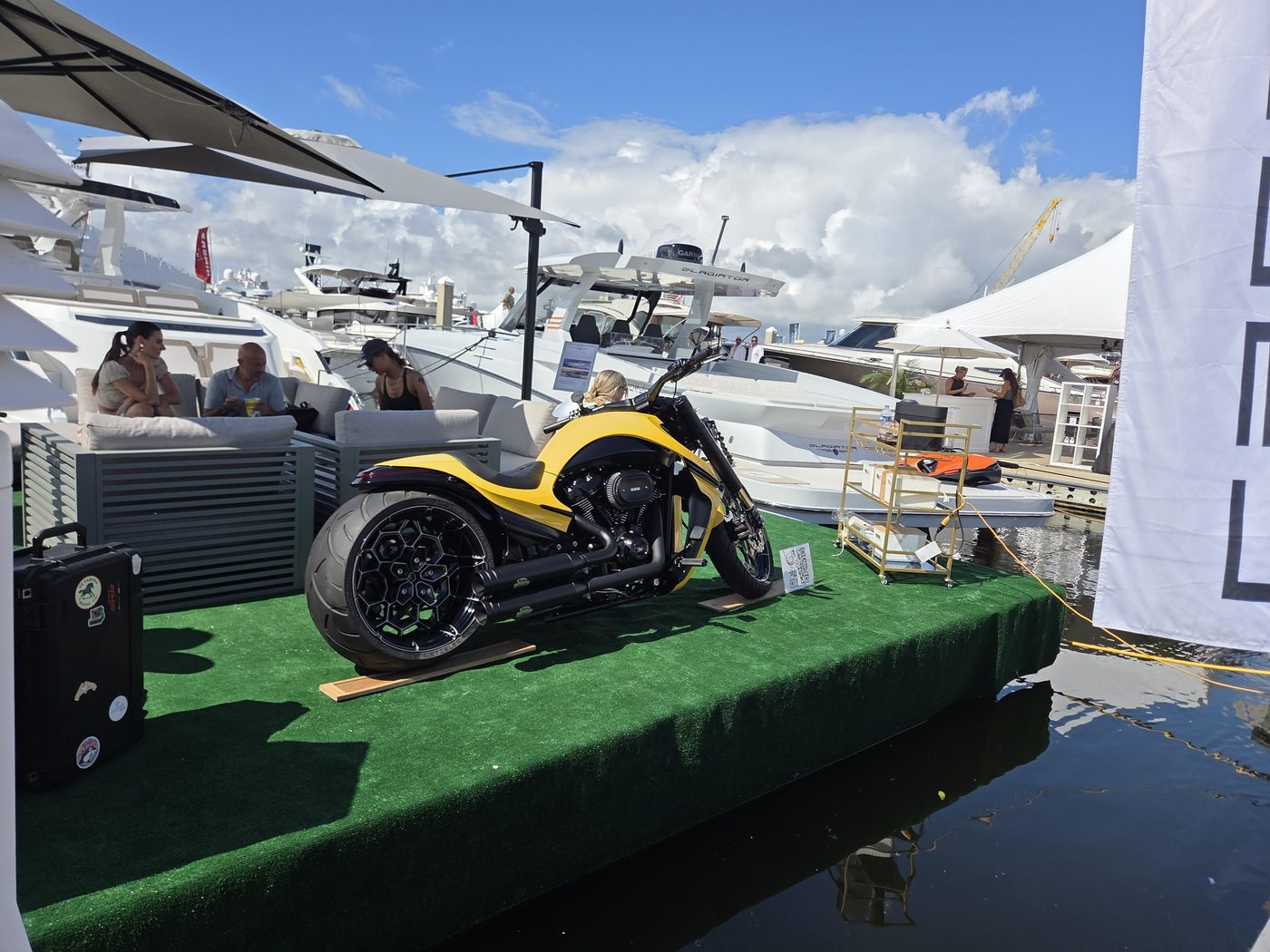 Yellow and black custom motorcycle on a turf dock at FLIBS 2026