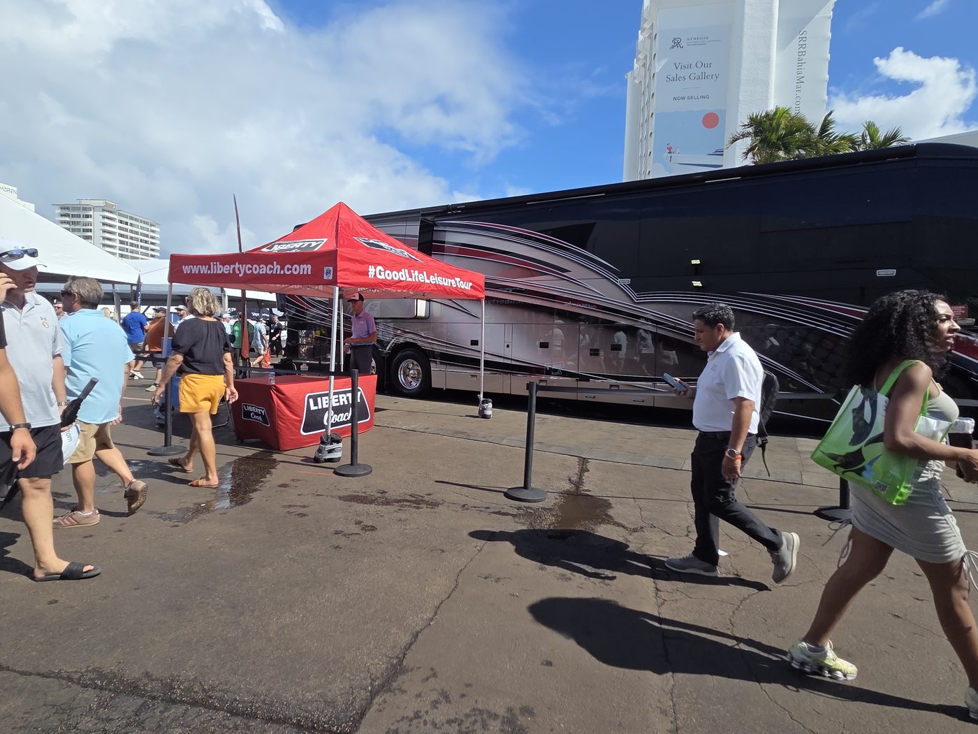 Show visitors crossing the lot past tour buses at FLIBS 2026