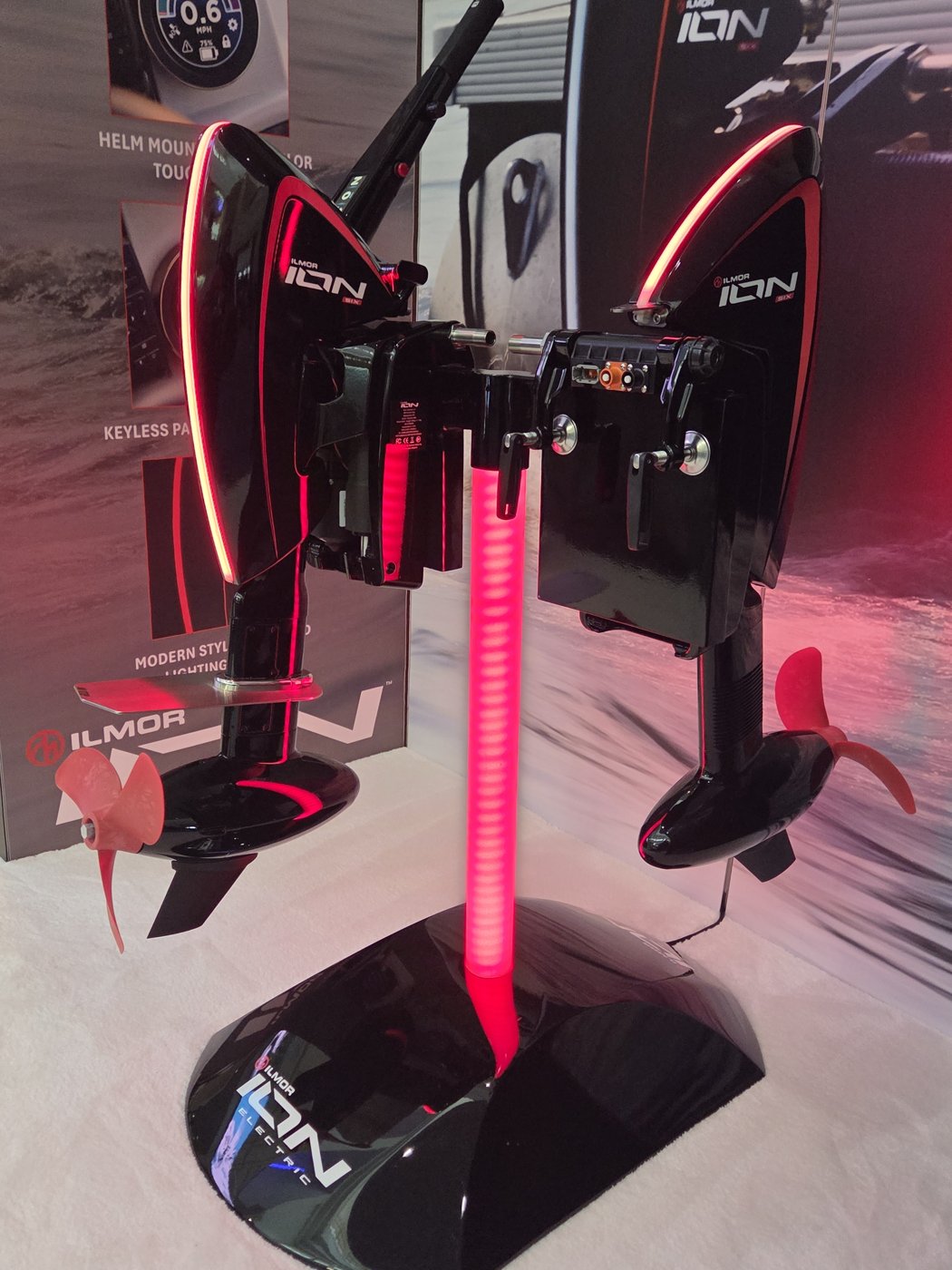 Twin Ilmor ION electric outboards on a red-lit display stand