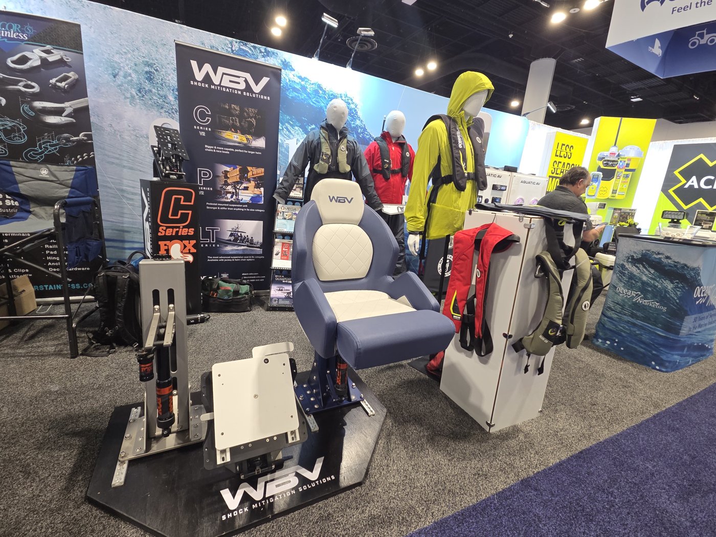 WBV Shock Mitigation Solutions booth with a blue and white helm seat and life jacket mannequins