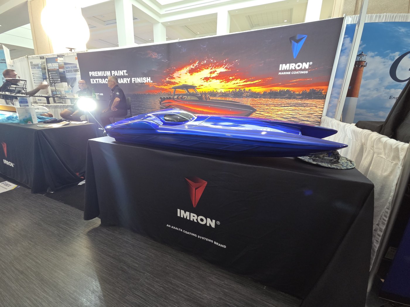 IMRON Marine Coatings booth by Axalta with a glossy blue powerboat model
