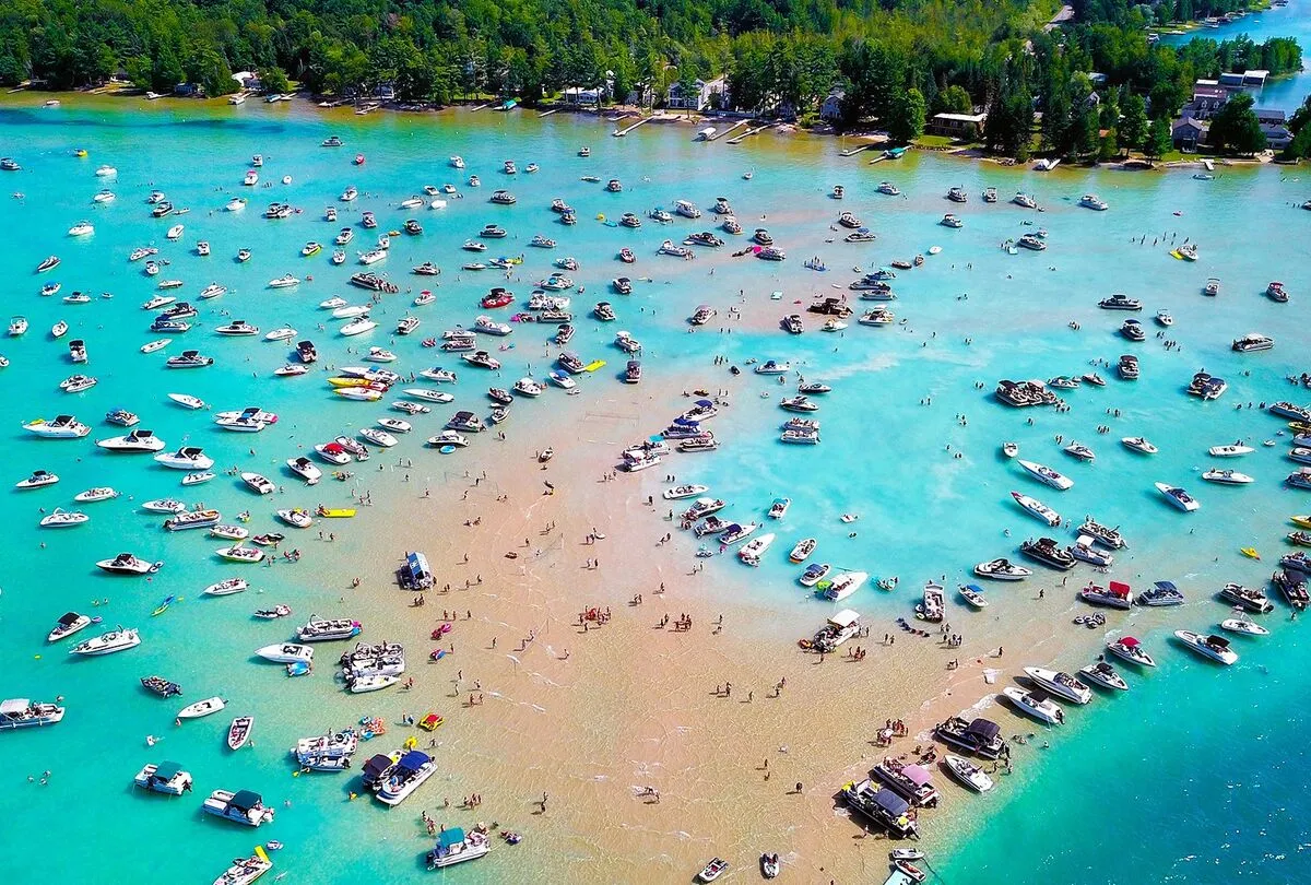 Aerial view of Torch Lake sandbar in Michigan with turquoise water and boats
