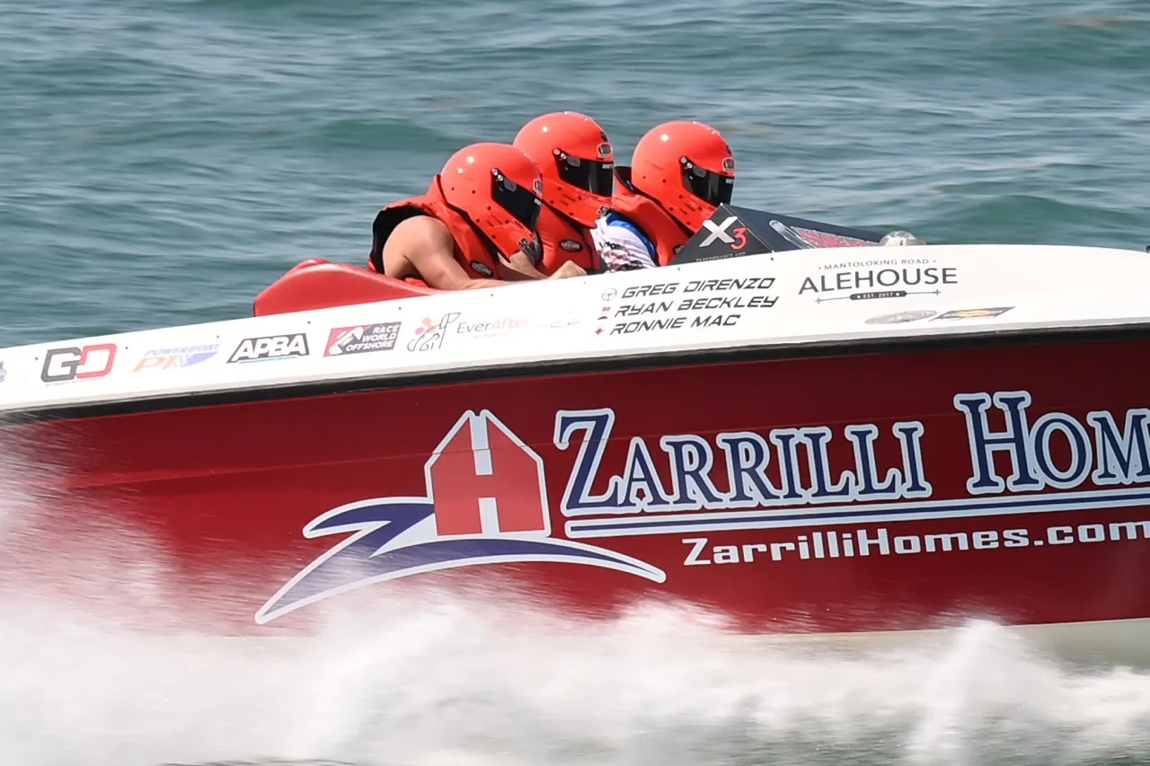 Spectators watching powerboat racing action from the shoreline