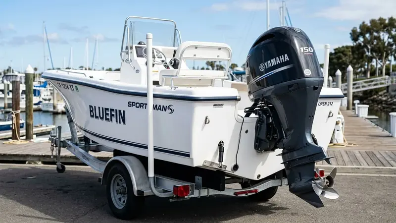Person holding smartphone scanning an outboard motor at a marina